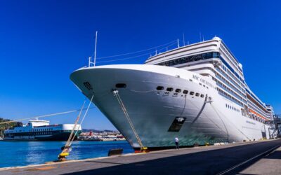 A large cruise ship docked at Barcelona port under a clear blue sky, showcasing maritime travel.
