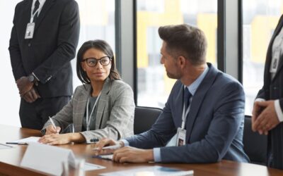 Diverse business professionals discussing strategy during a modern board meeting.