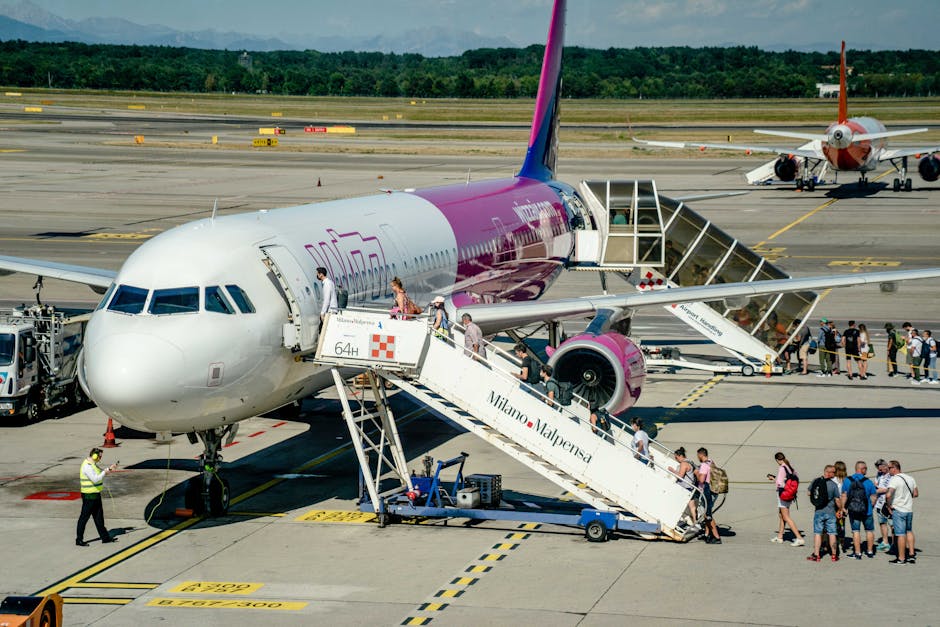 Travelers boarding an airplane on a sunny day