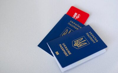 Close-up of Ukrainian passports and travel card on a light surface with ample copy space.