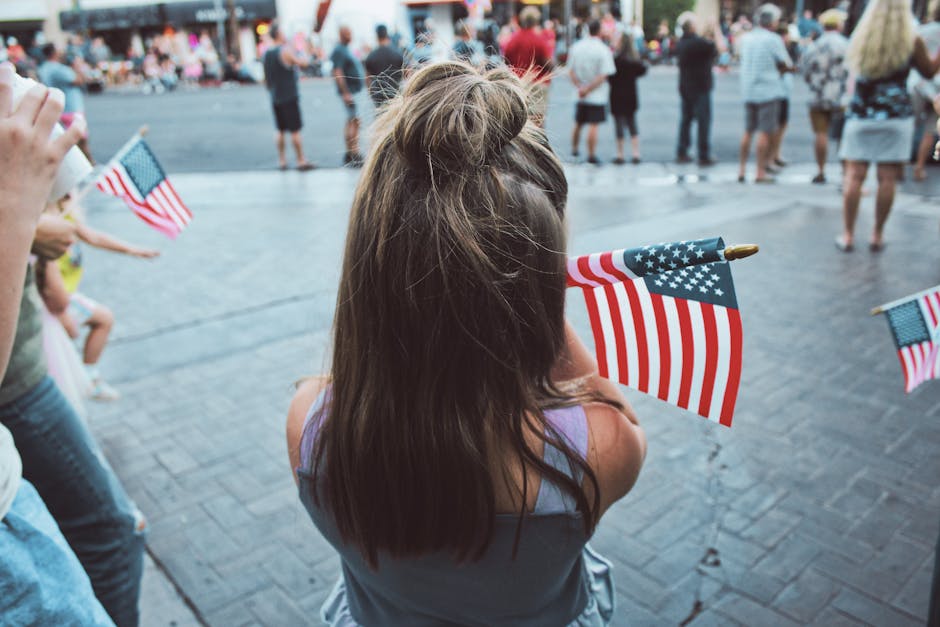 Memorial Day weekend - young girl holding American flag at patriotic street event
