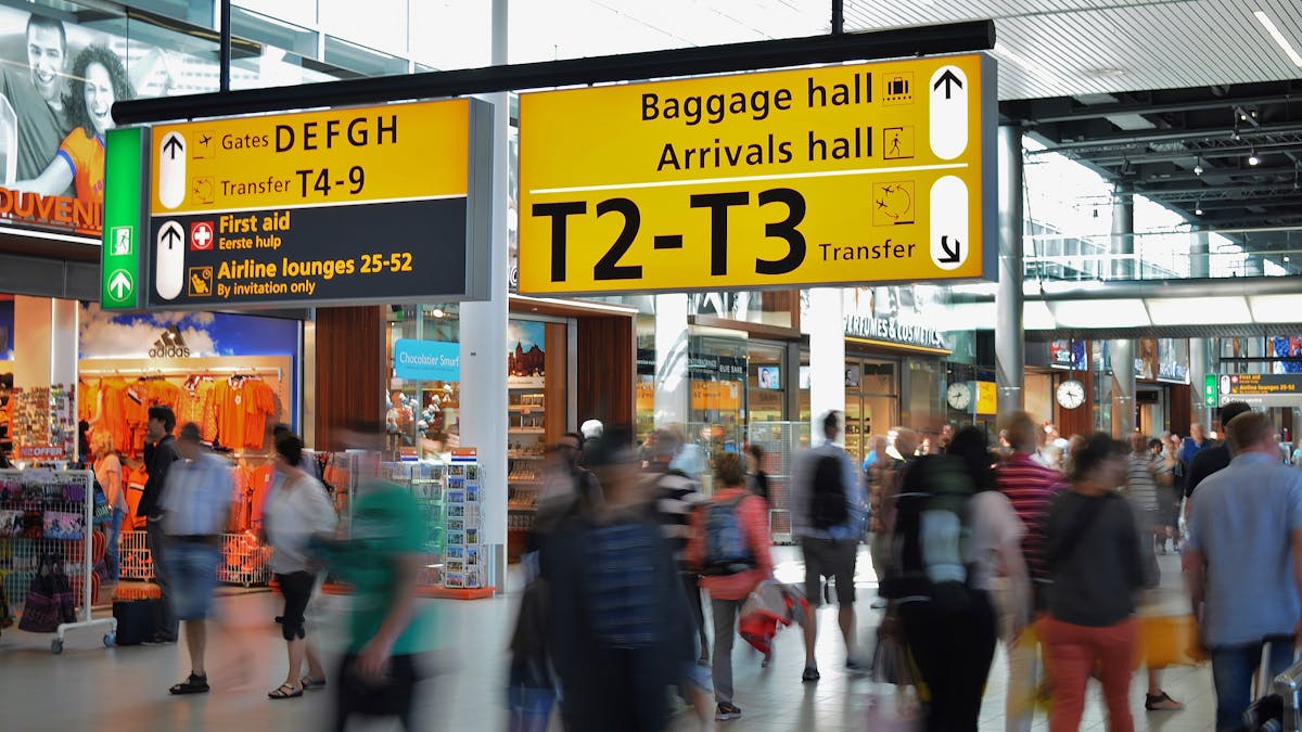 Travelers in an airport transit hall affected by ESTA transit refused rules