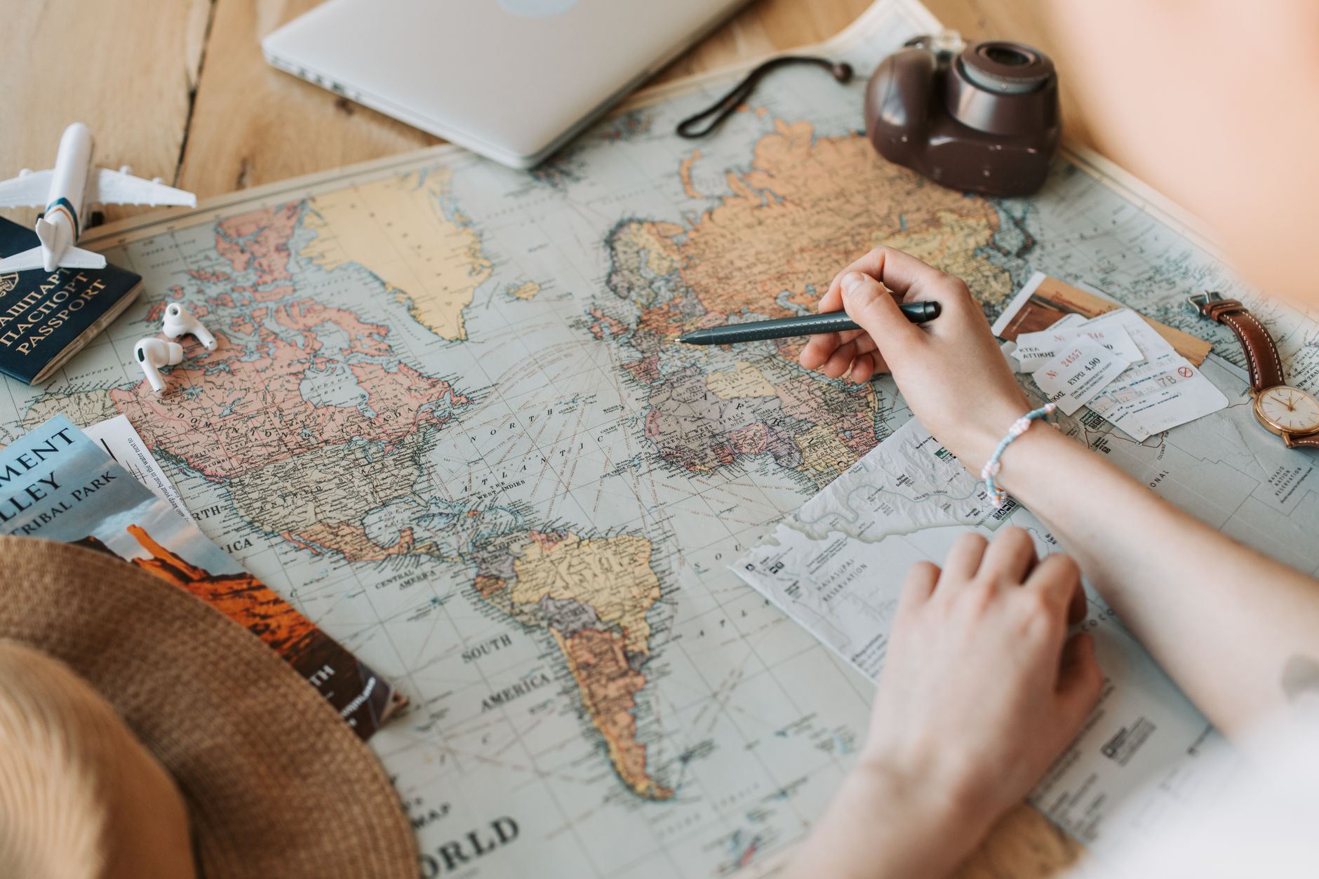 Traveller marking United States destinations on a world map while planning trip insurance