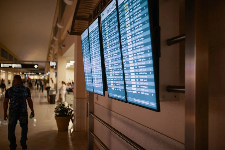 Traveler holding a passport and printed ESTA return ticket at a US airport check-in desk