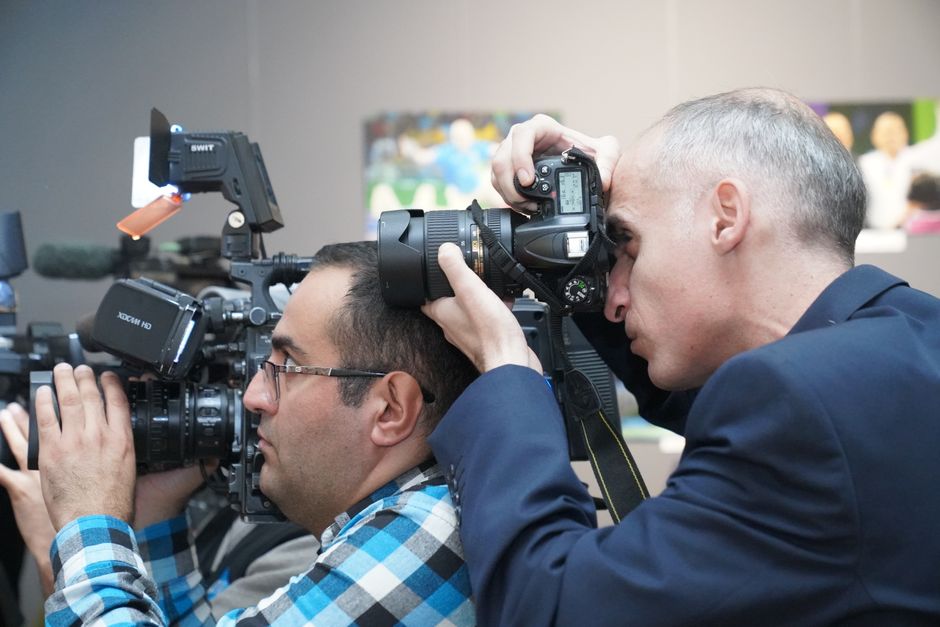 Documentary film crew setting up lighting and camera equipment on location