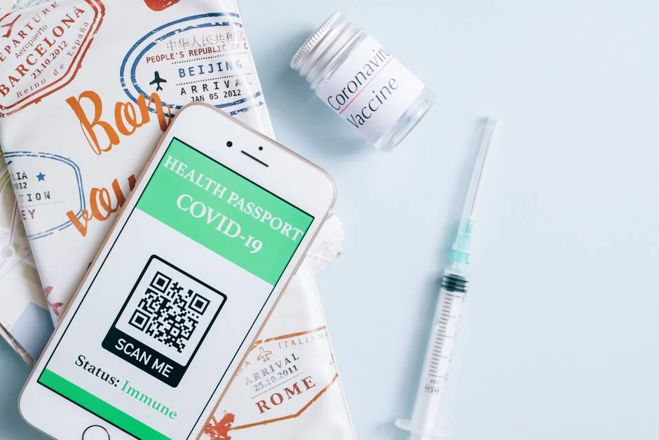 Traveler holding a passport and vaccination card while checking ESTA vaccination requirements for the US