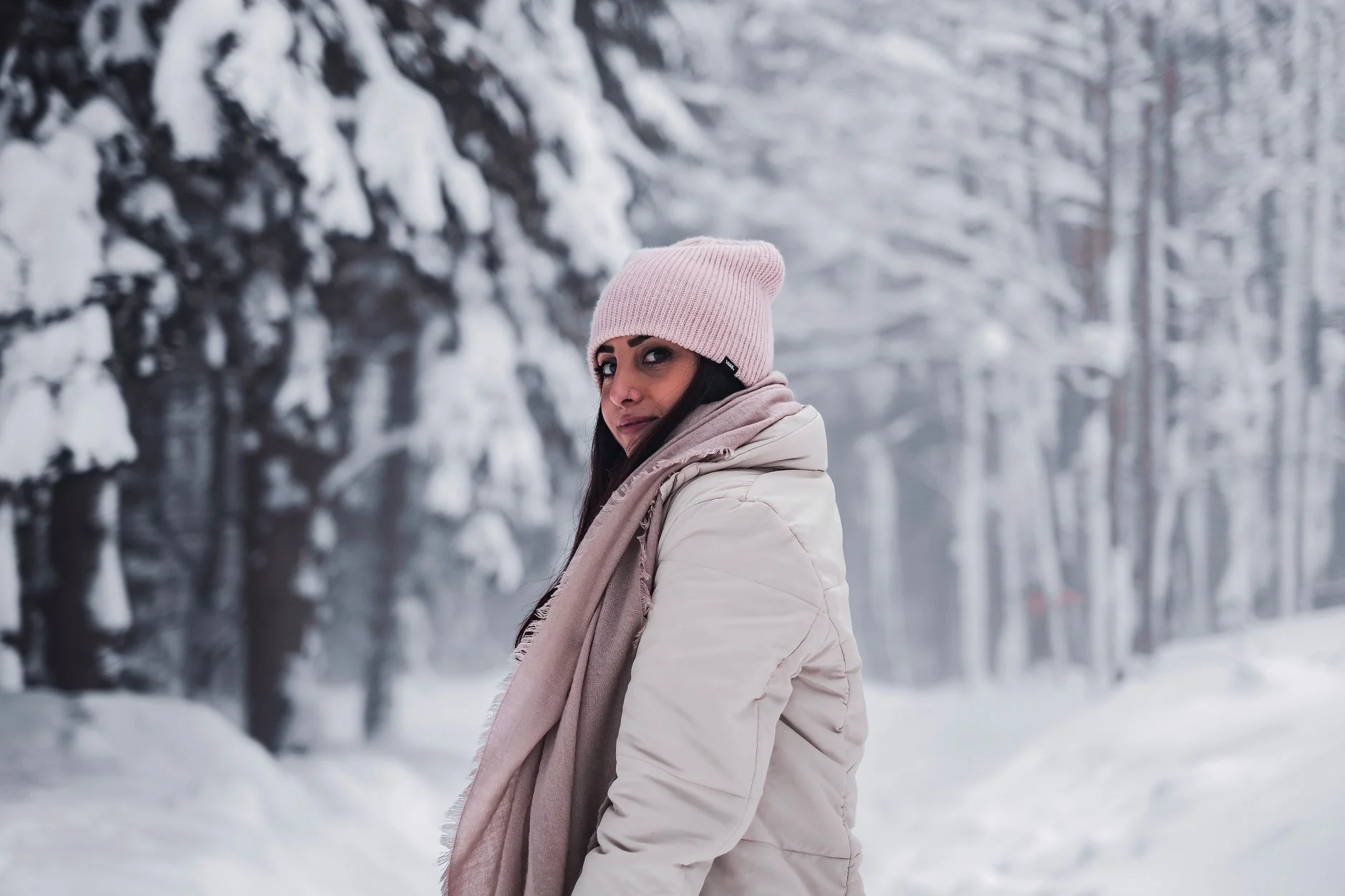 Woman in a warm coat and beanie in the snow dressed for a northern US winter