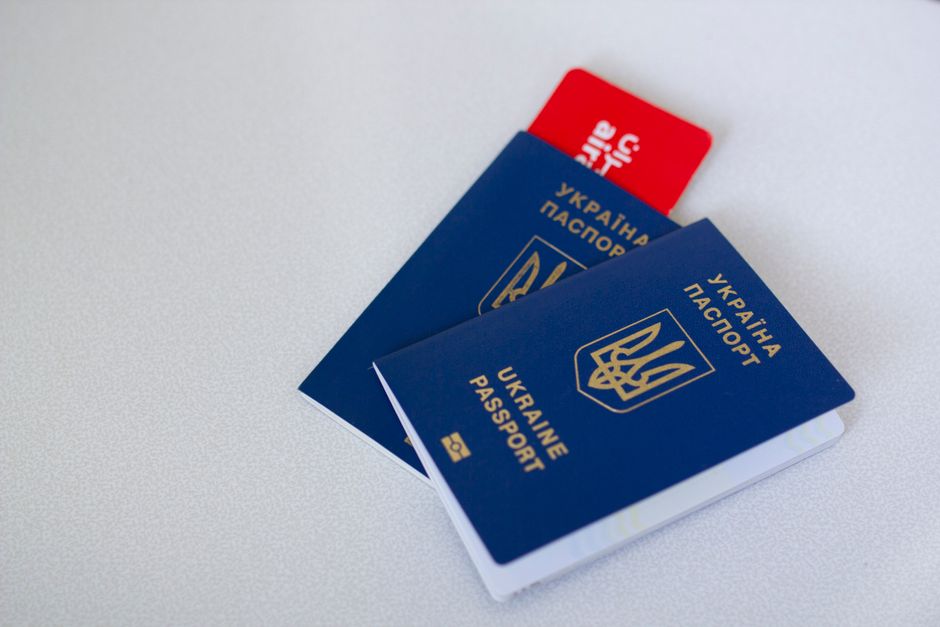 Two different national passports lying side by side on a wooden desk