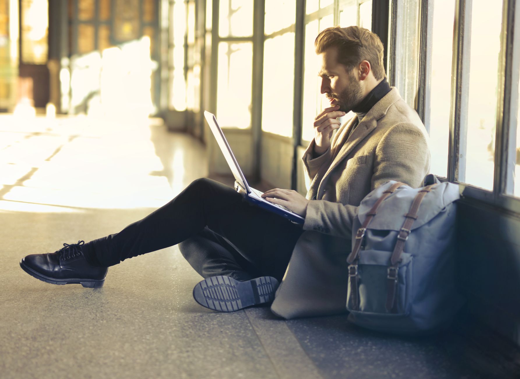 A business traveler with a laptop bag at an airport departure lounge