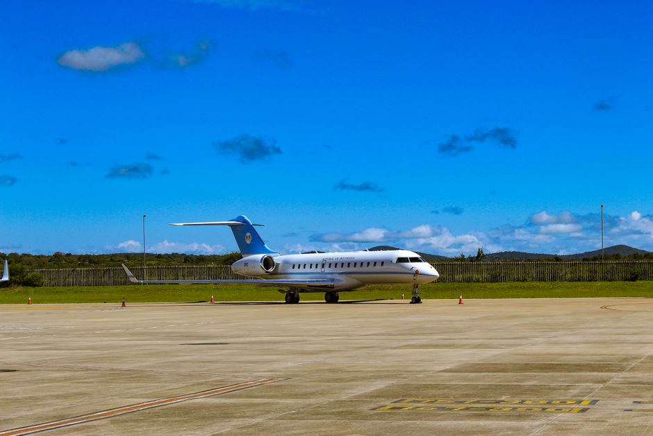 Private charter aircraft parked at a terminal with ground crew preparing for departure