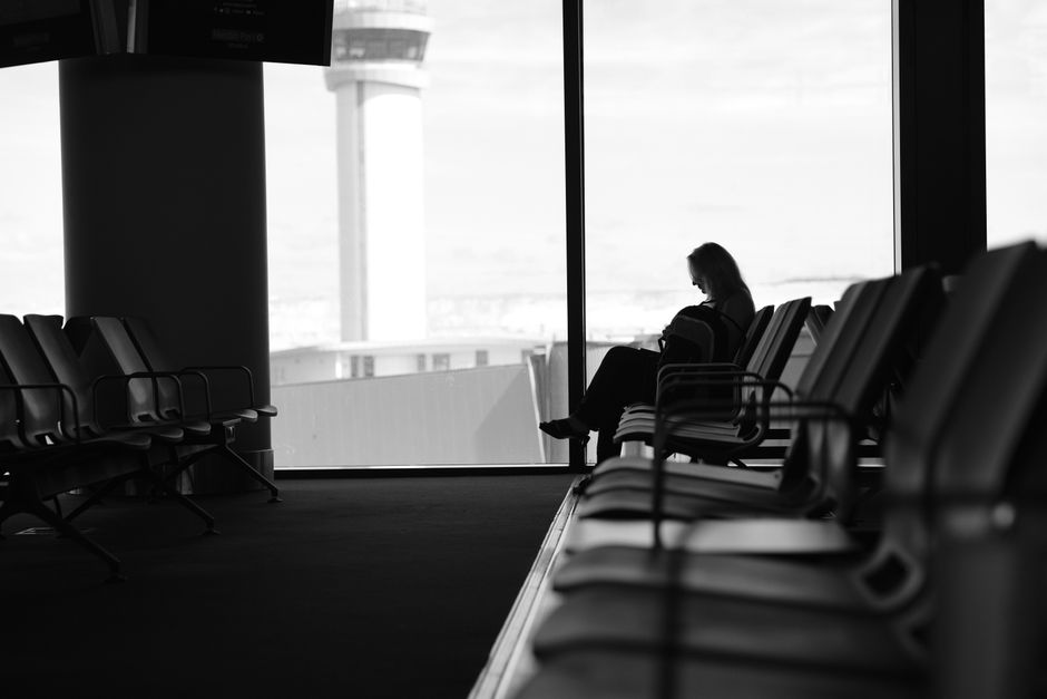 Tired traveller resting across seats during an overnight US airport layover